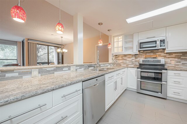 kitchen with decorative light fixtures, sink, stainless steel appliances, backsplash, and white cabinets