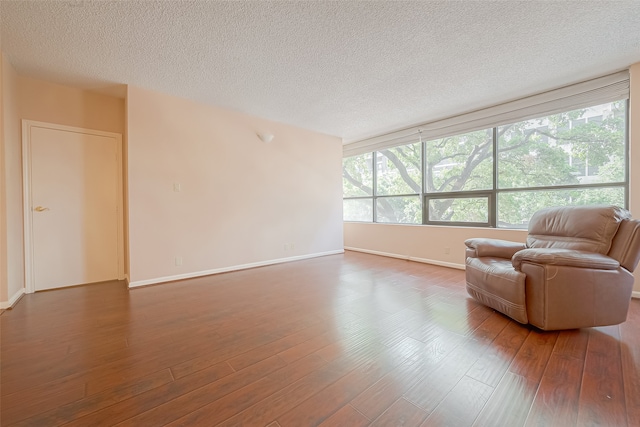 unfurnished living room with dark hardwood / wood-style floors and a textured ceiling