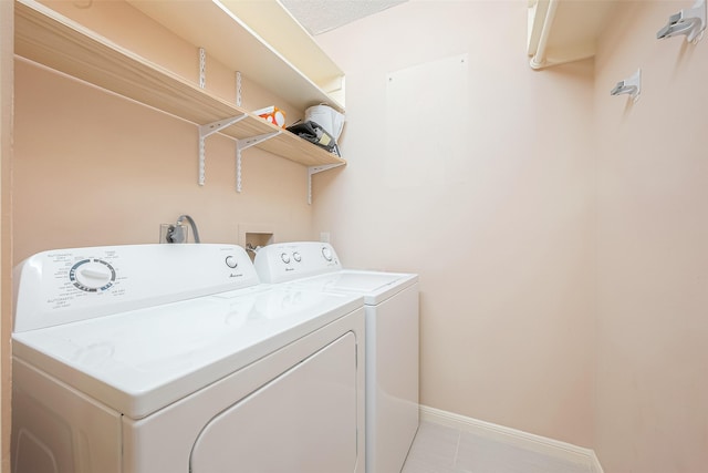 5150 Hidalgo St Unit 204, Houston, TX 77056 - laundry room featuring washer and clothes dryer, baseboards, and light tile patterned flooring