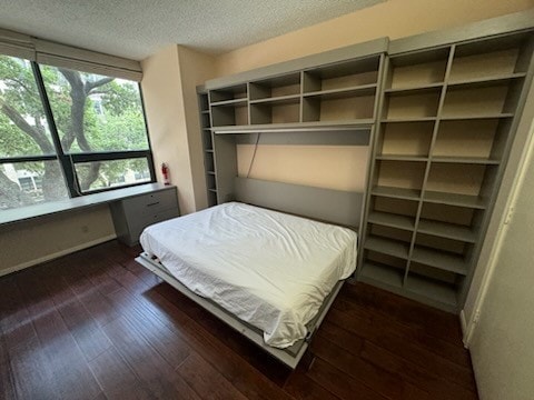 bedroom with dark hardwood / wood-style flooring and a textured ceiling