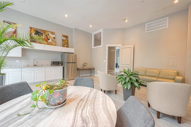 dining space with sink and light hardwood / wood-style floors