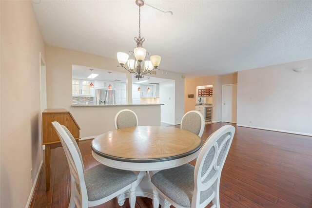 dining space with an inviting chandelier, dark hardwood / wood-style floors, and a textured ceiling