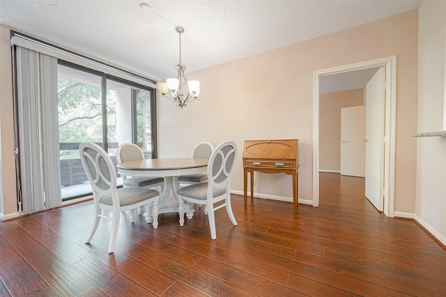 dining area with a notable chandelier, a textured ceiling, baseboards, and wood finished floors