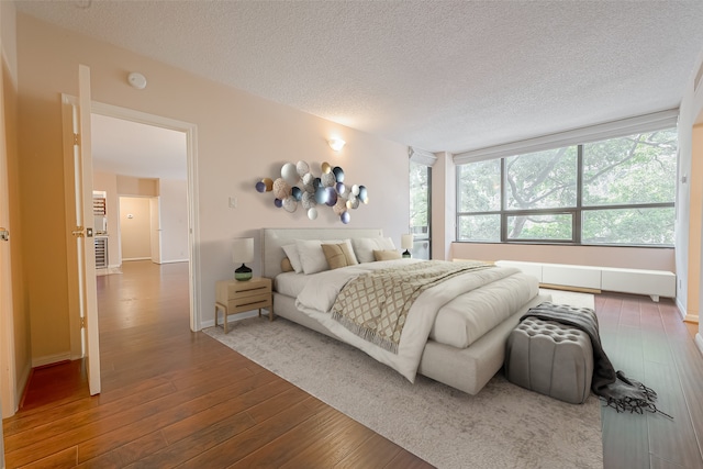 bedroom with hardwood / wood-style floors and a textured ceiling