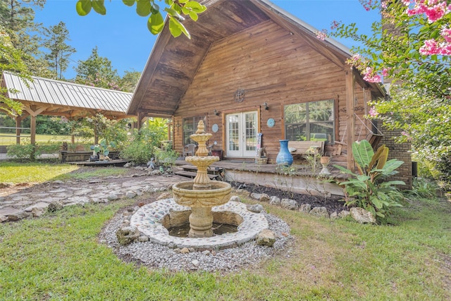 rear view of property featuring french doors and a lawn