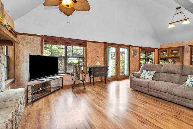 living room featuring high vaulted ceiling, french doors, light wood-type flooring, and ceiling fan