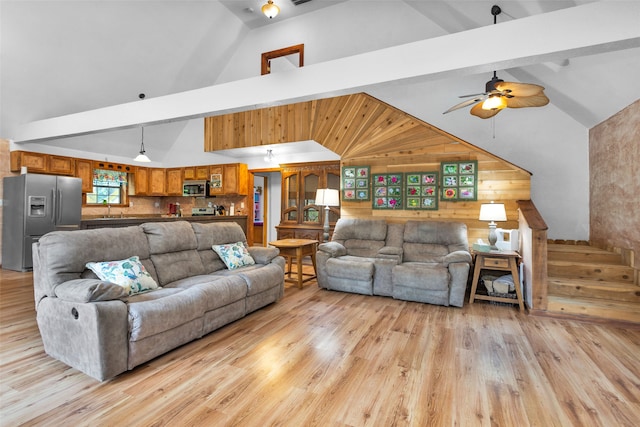 living room featuring sink, ceiling fan, light hardwood / wood-style floors, and beam ceiling