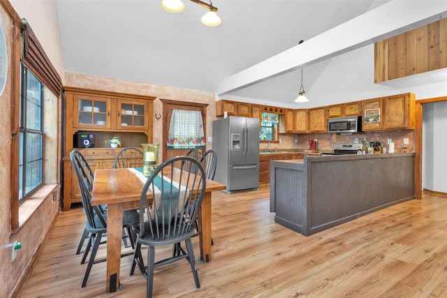 dining room featuring beam ceiling, light hardwood / wood-style floors, sink, and high vaulted ceiling