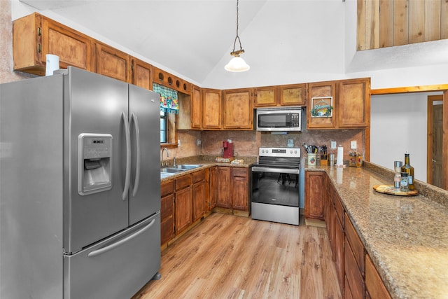 kitchen featuring backsplash, light hardwood / wood-style floors, appliances with stainless steel finishes, sink, and high vaulted ceiling