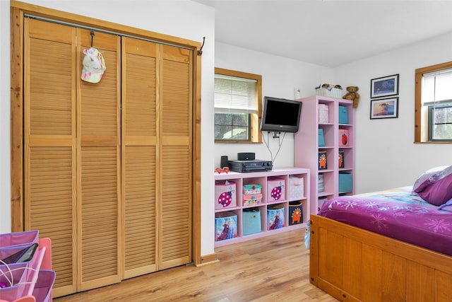 bedroom with light wood-type flooring and a closet