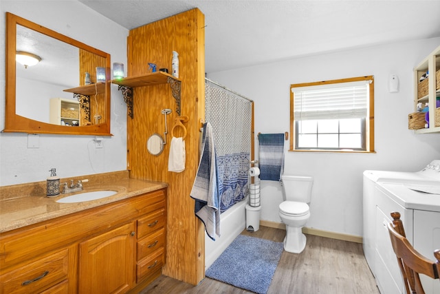 bathroom with vanity, toilet, hardwood / wood-style floors, and washer and clothes dryer