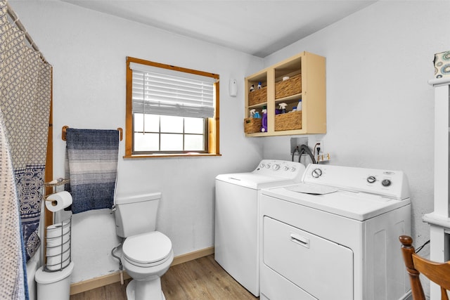 clothes washing area featuring washing machine and dryer and light wood-type flooring