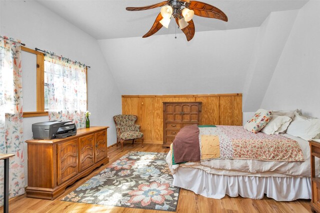 bedroom with ceiling fan, lofted ceiling, and light hardwood / wood-style floors