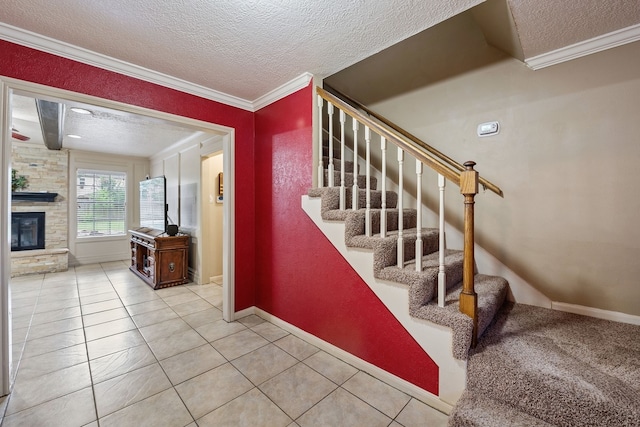 staircase featuring a fireplace, ornamental molding, a textured ceiling, and tile patterned flooring