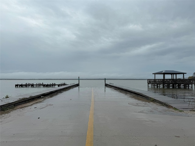 view of dock with a gazebo and a water view