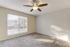 carpeted empty room featuring ceiling fan