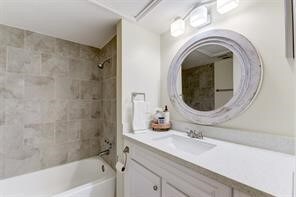 bathroom featuring vanity and tiled shower / bath