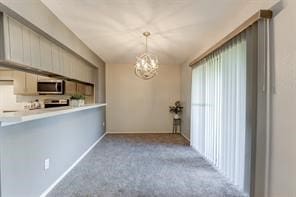 interior space featuring an inviting chandelier and light carpet