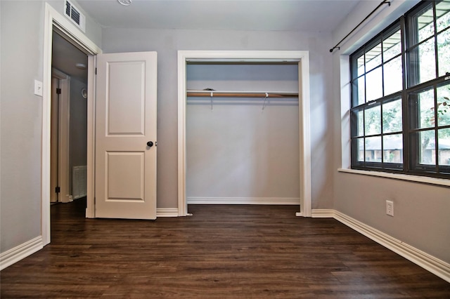 unfurnished bedroom with a closet and dark hardwood / wood-style floors