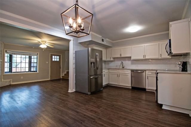 kitchen featuring pendant lighting, white cabinets, ceiling fan with notable chandelier, appliances with stainless steel finishes, and tasteful backsplash