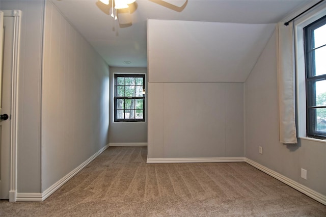 bonus room with ceiling fan, plenty of natural light, light colored carpet, and lofted ceiling