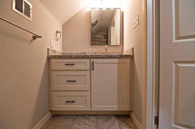 bathroom featuring tile patterned floors, vanity, and lofted ceiling