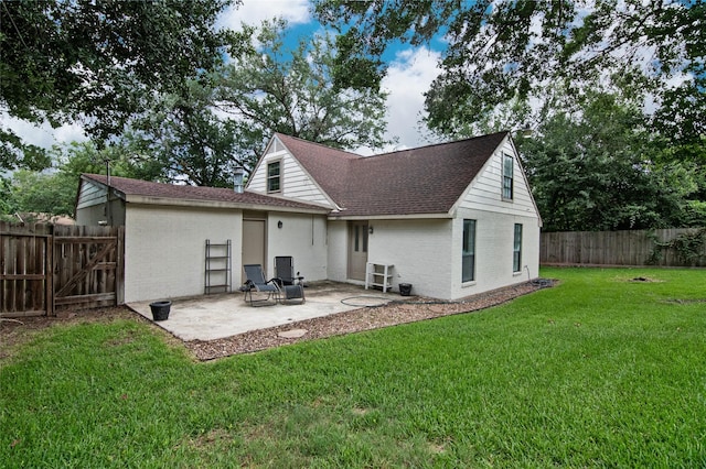 rear view of house with a lawn and a patio area