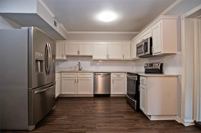 kitchen with sink, white cabinets, ornamental molding, and appliances with stainless steel finishes