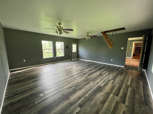 unfurnished living room featuring a textured ceiling, dark hardwood / wood-style floors, and ceiling fan