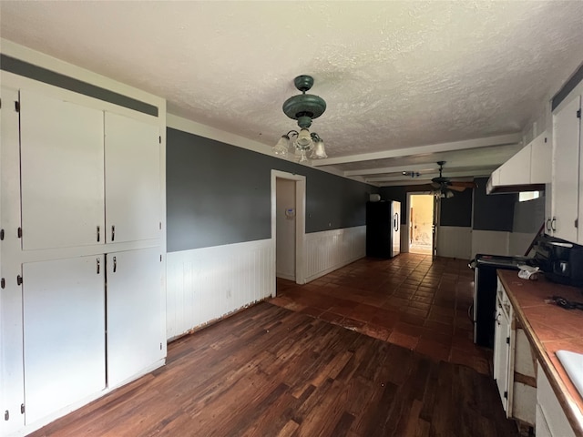 kitchen featuring ceiling fan, stainless steel fridge, a textured ceiling, electric range oven, and white cabinets