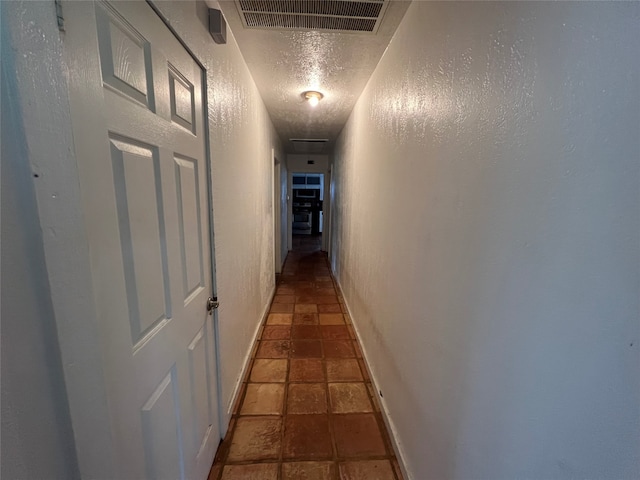 corridor featuring tile floors and a textured ceiling