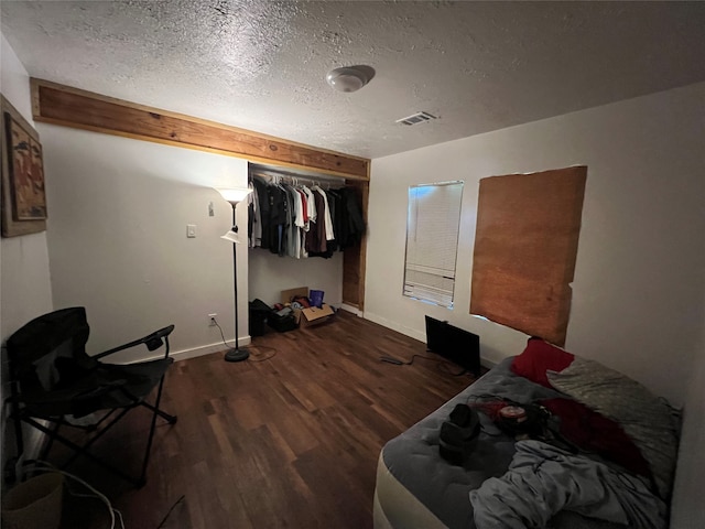 bedroom featuring hardwood / wood-style floors, a closet, and a textured ceiling