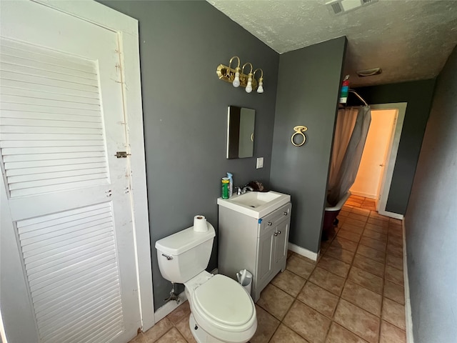 bathroom with vanity, toilet, and tile floors