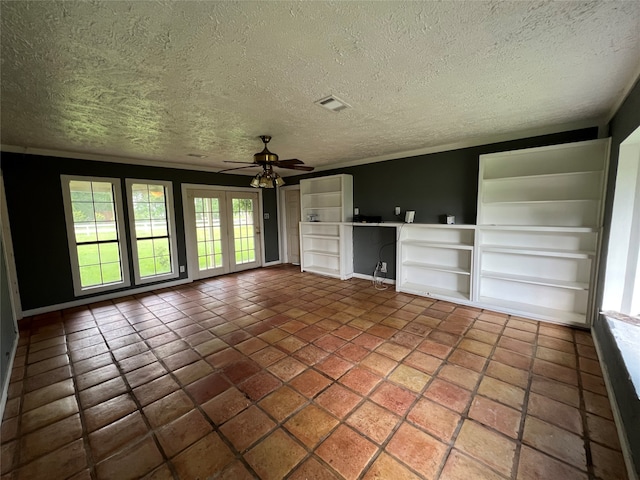 unfurnished living room with a textured ceiling, ornamental molding, built in shelves, dark tile flooring, and ceiling fan