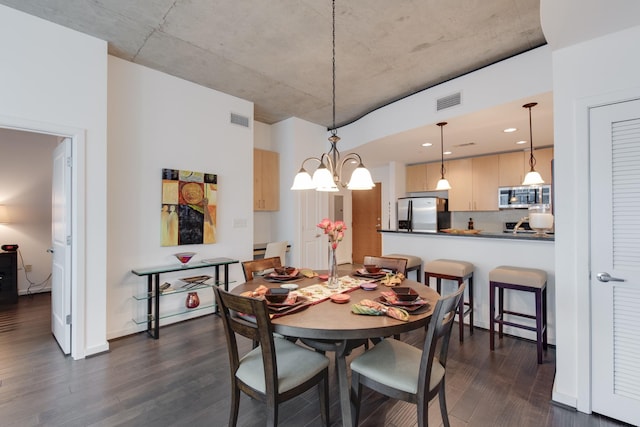 dining space with dark hardwood / wood-style flooring and a chandelier