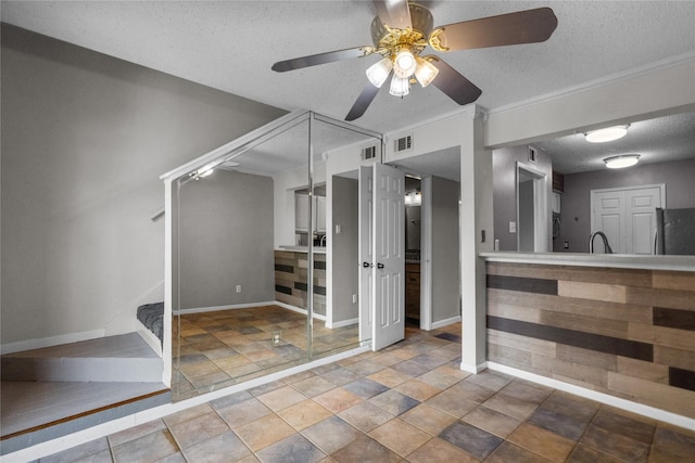 interior space with ceiling fan and a textured ceiling