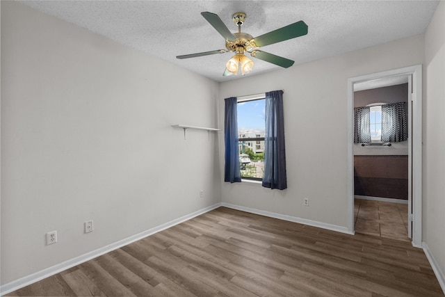 unfurnished room featuring hardwood / wood-style flooring, ceiling fan, and a textured ceiling