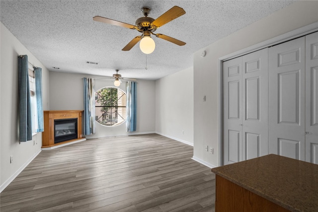 unfurnished living room with dark hardwood / wood-style floors and a textured ceiling