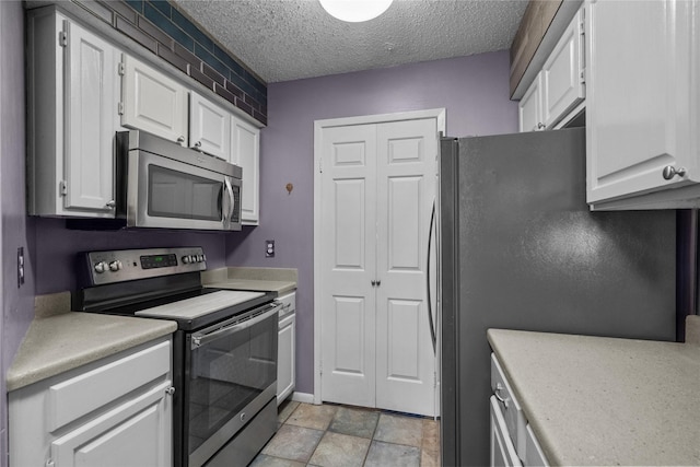 kitchen with a textured ceiling, white cabinets, and appliances with stainless steel finishes