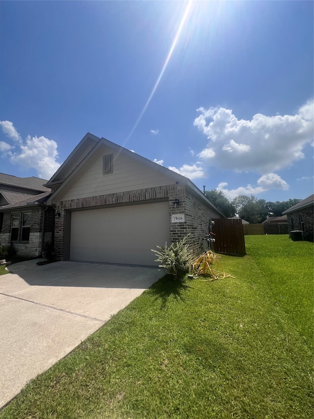 view of side of property with a garage and a lawn