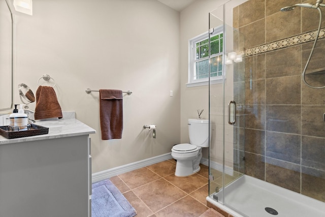 bathroom with tile patterned floors, toilet, a shower with door, and vanity