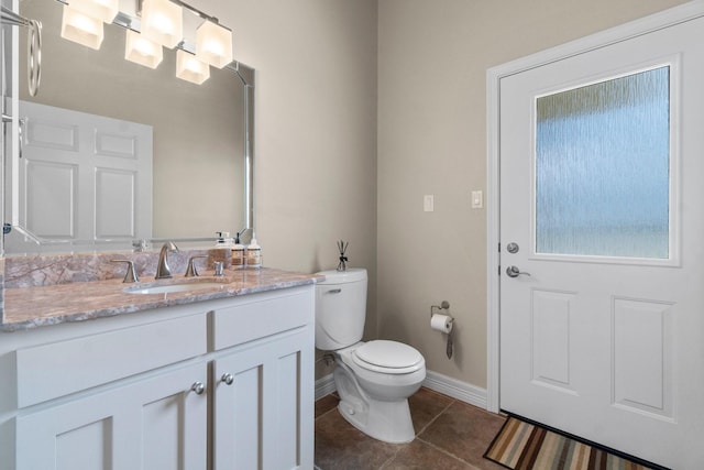 bathroom featuring toilet, vanity, and tile patterned flooring