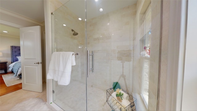 bathroom featuring hardwood / wood-style floors, a shower with shower door, and ornamental molding