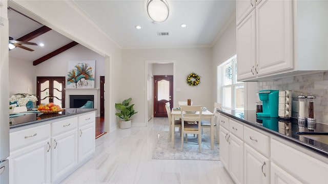 kitchen with light tile patterned flooring, white cabinetry, ceiling fan, decorative backsplash, and lofted ceiling with beams