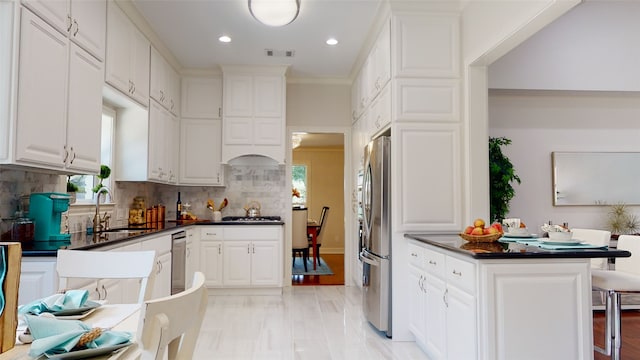 kitchen with sink, appliances with stainless steel finishes, white cabinets, and backsplash