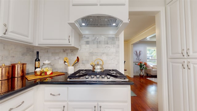 kitchen featuring decorative backsplash, white cabinetry, dark hardwood / wood-style floors, and stainless steel gas stovetop