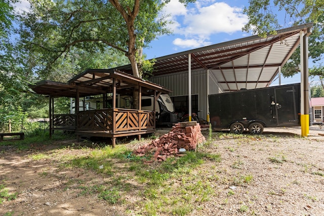 exterior space featuring dirt driveway and a detached carport