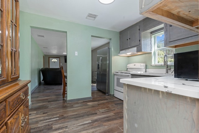 kitchen with white electric stove, a sink, visible vents, stainless steel fridge, and dark wood finished floors