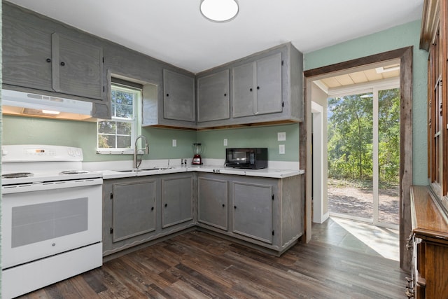 kitchen with electric stove, gray cabinets, light countertops, a sink, and under cabinet range hood