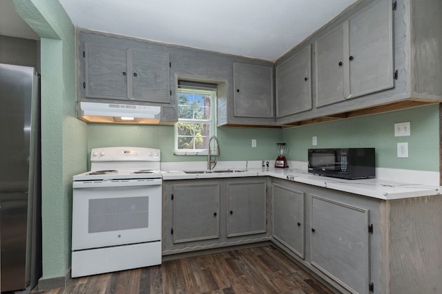 kitchen featuring black microwave, under cabinet range hood, electric stove, light countertops, and freestanding refrigerator